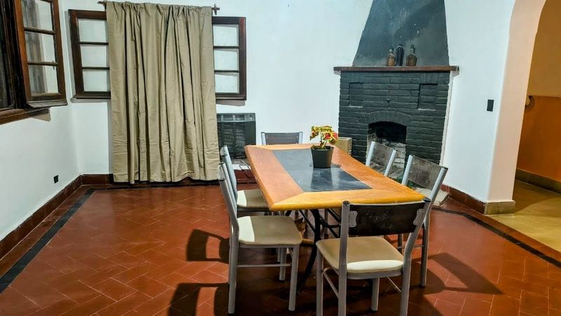 Comedor con mesa larga, sillas y chimenea